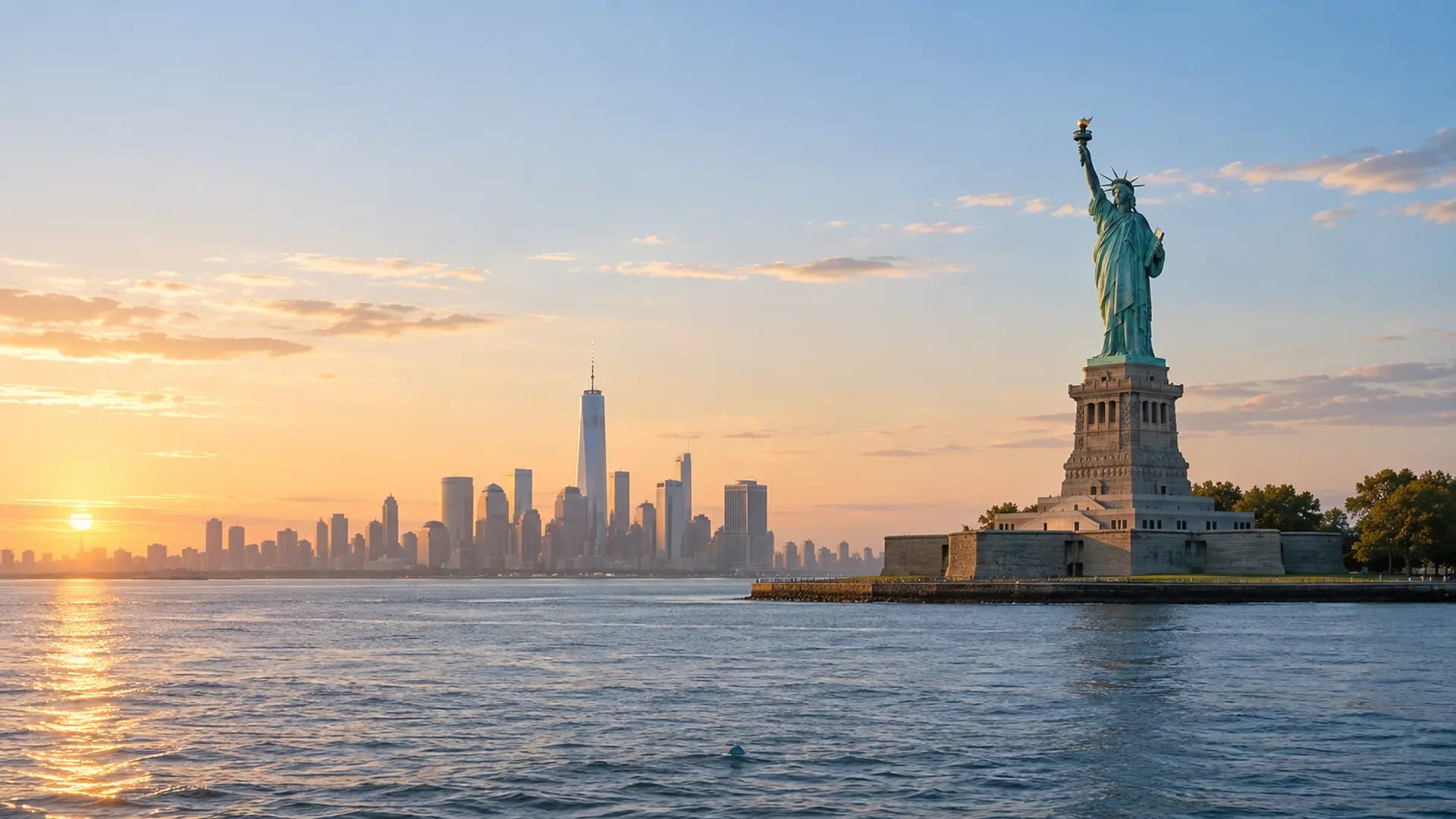La Statue de la Liberté devant la skyline de New York au lever du soleil