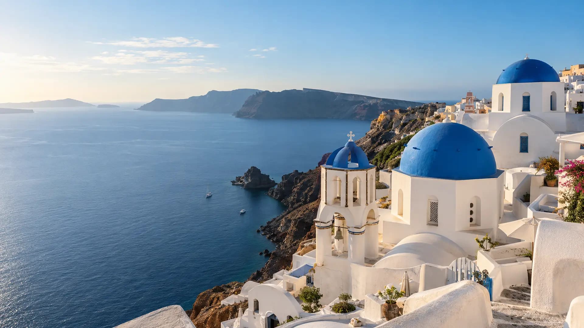 Les maisons blanches et les dômes bleus d’Oia face à la mer Égée